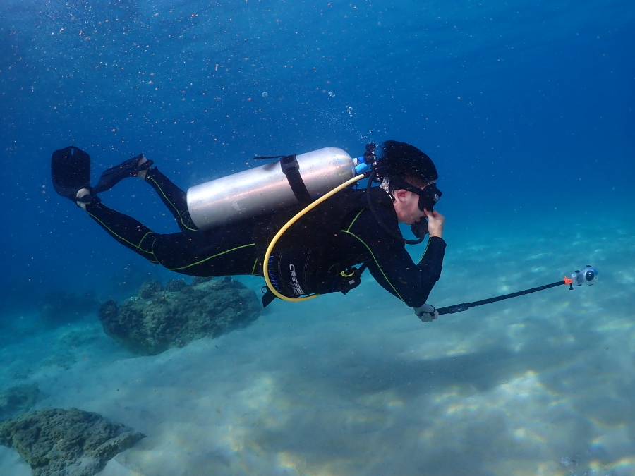 西オアフのクリアな水中をアクションカメラを手に美しいフォームで泳ぐファンダイバー