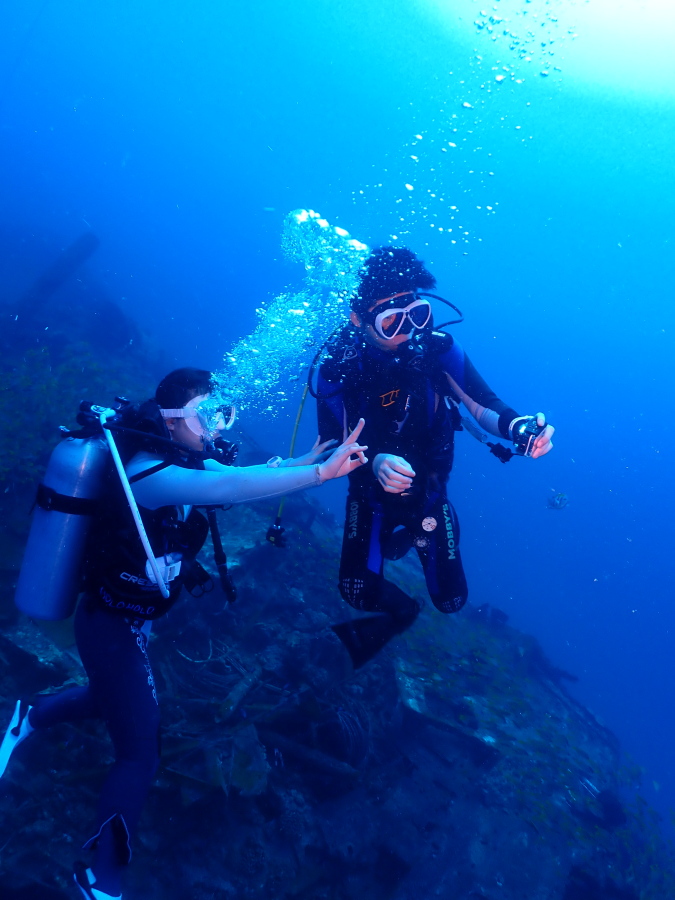 ハワイの水深30mの沈船シータイガーでカメラ撮影を楽しみながらポーズをとる二人